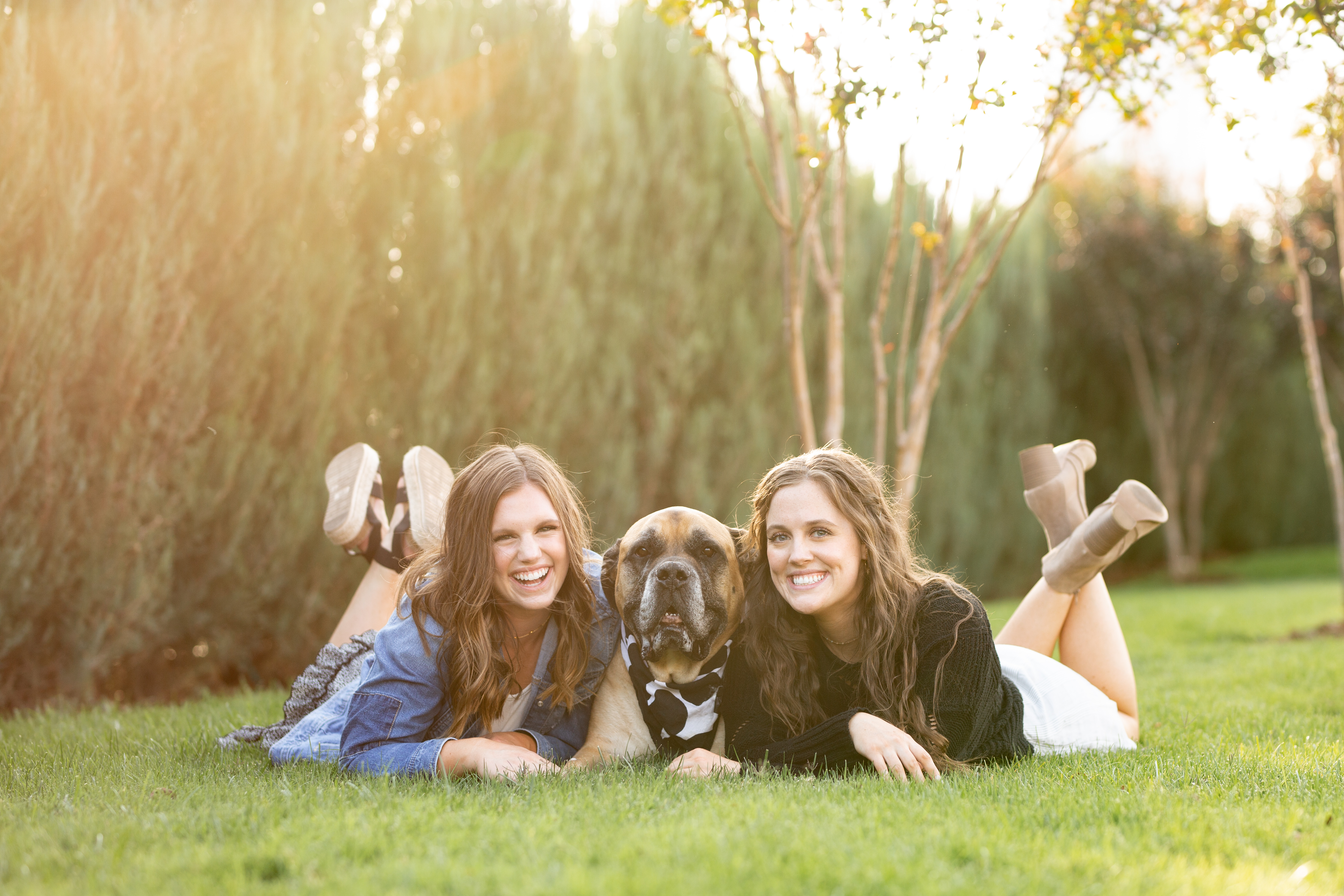 sisters posing with their dog for pictures