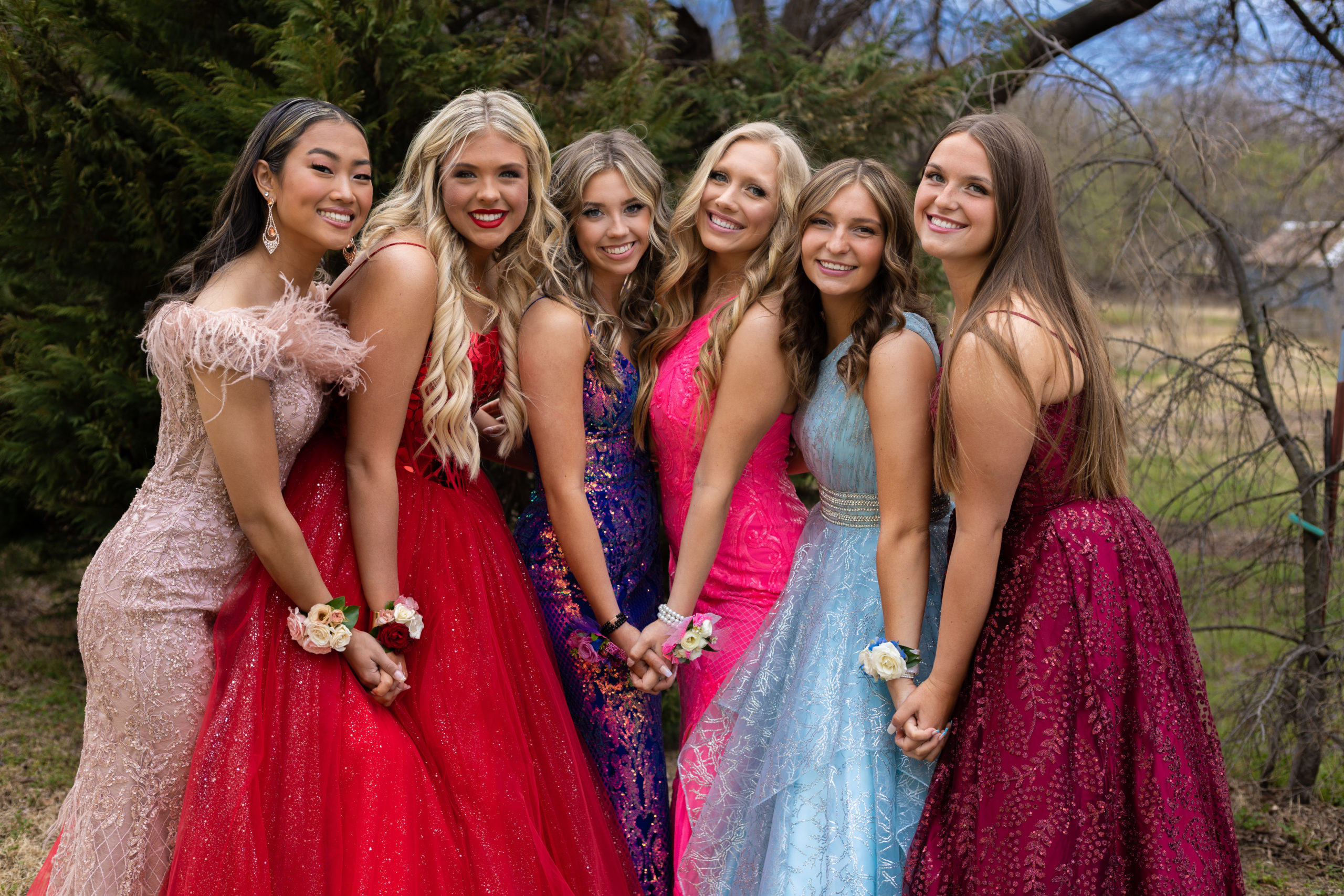 A group of high school girls posing for prom pictures