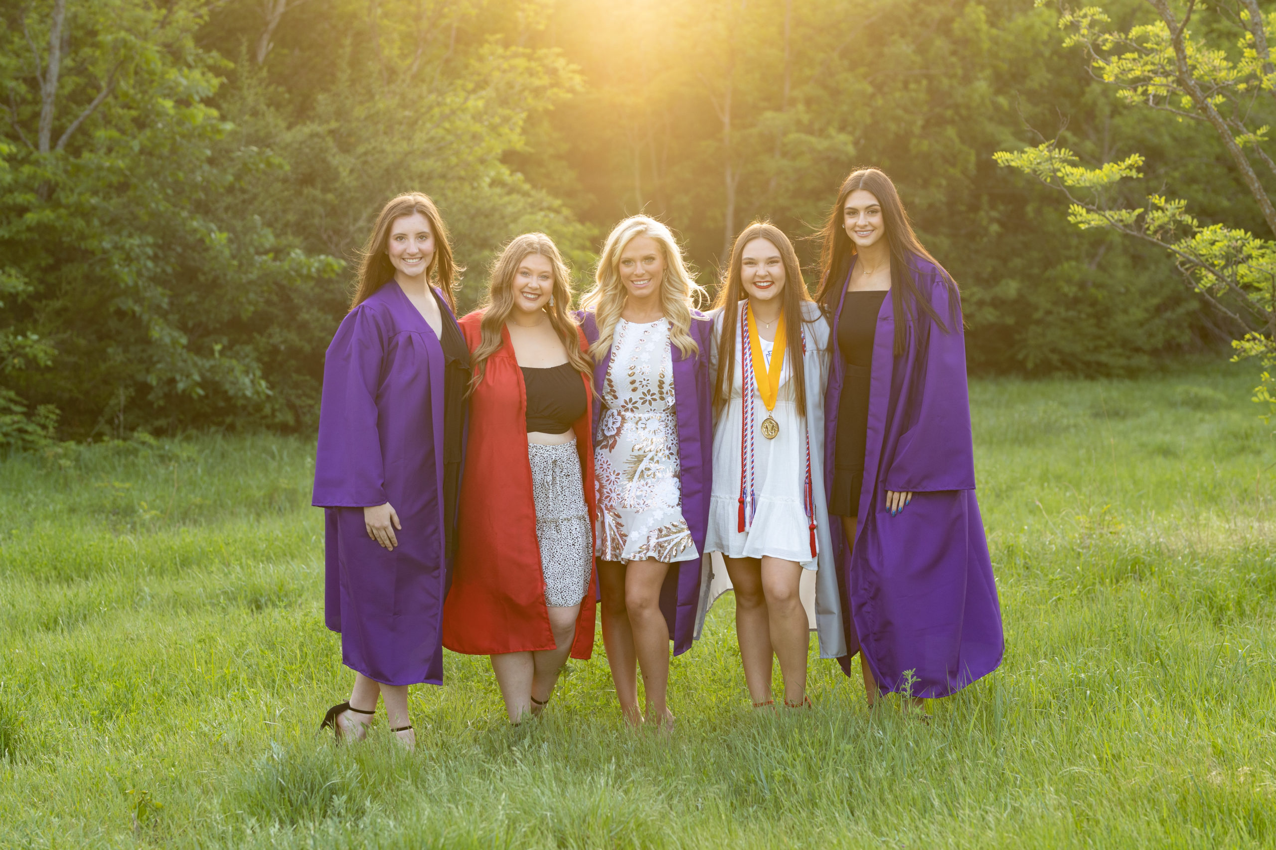 group of high school senior girls taking pictures in their graduation cap and gowns