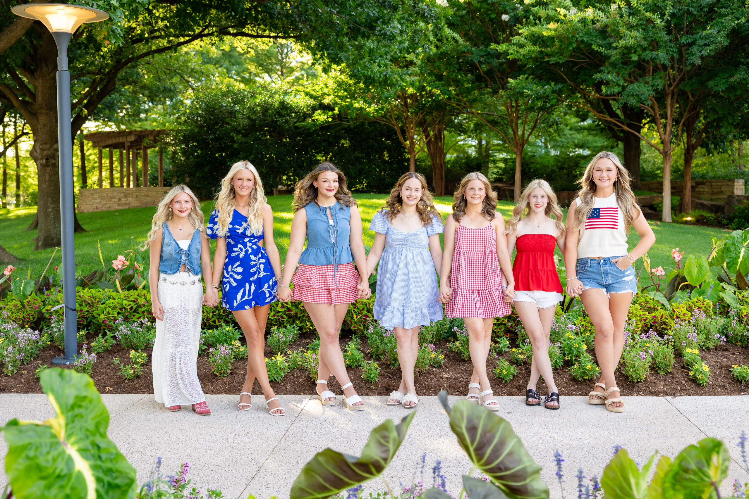 a group of senior girls posing in downtown Oklahoma City for a 4th of July senior rep team session