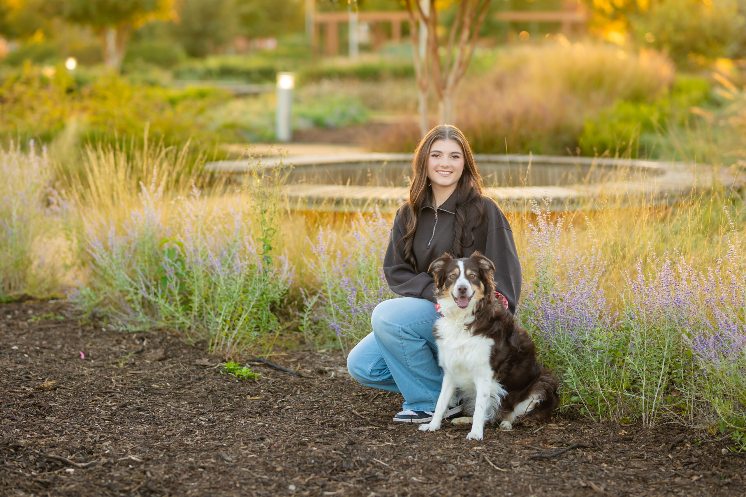 senior girl posing with her dog in downtown OKC for her senior photos